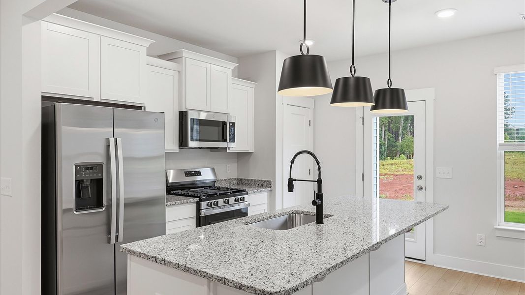 Tasteful kitchen with a center island and stylish pendant lighting—crafted to high standards in Lyman, SC Tasteful kitchen with a center island and stylish pendant lighting—crafted to high standards in Lyman, SC