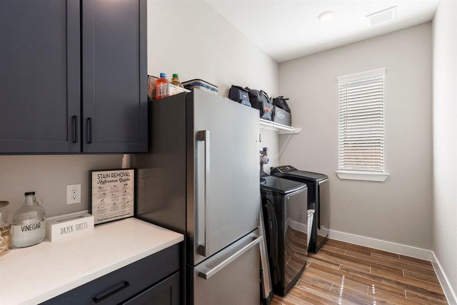 This laundry room has tons of storage and room for a fridge!