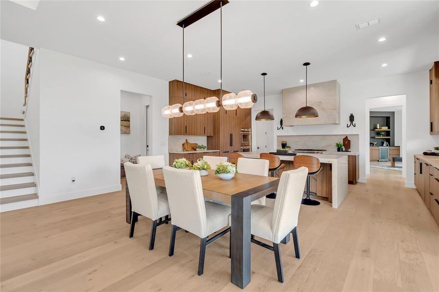 Dining room featuring stairway, light wood-style flooring, and recessed lighting Dining room featuring stairway, light wood-style flooring, and recessed lighting