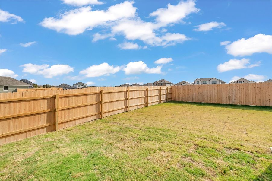 Fenced backyard featuring a residential view