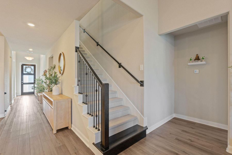 Welcoming entryway featuring a modern staircase with upgraded carpeting found throughout the home complimented with dark wood railing and light wood flooring. Welcoming entryway featuring a modern staircase with upgraded carpeting found throughout the home complimented with dark wood railing and light wood flooring.
