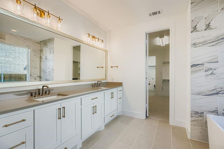 Bathroom featuring double vanity, a walk in closet, a marble finish shower, light tile patterned floors, and a tub to relax in Bathroom featuring double vanity, a walk in closet, a marble finish shower, light tile patterned floors, and a tub to relax in