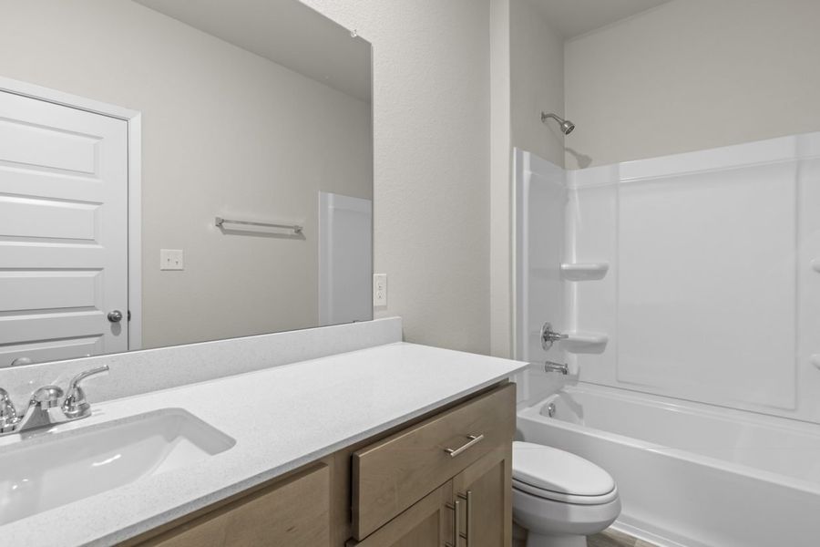 Image of a bathroom with a white dual vanity, a large mirror, and a white shower with a tub Image of a bathroom with a white dual vanity, a large mirror, and a white shower with a tub