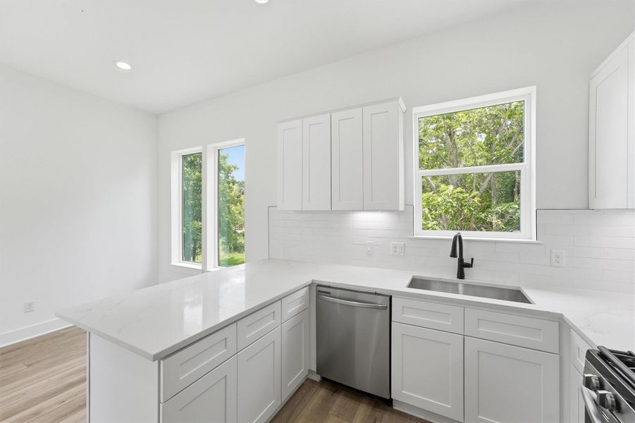 Entertain with ease in this beautifully designed kitchen. The extended quartz peninsula, stainless appliances, and oversized windows create a space that feels just as good for hosting friends as it does for quiet weeknight dinners. Entertain with ease in this beautifully designed kitchen. The extended quartz peninsula, stainless appliances, and oversized windows create a space that feels just as good for hosting friends as it does for quiet weeknight dinners.