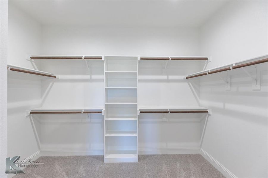 Walk in closet featuring light carpet