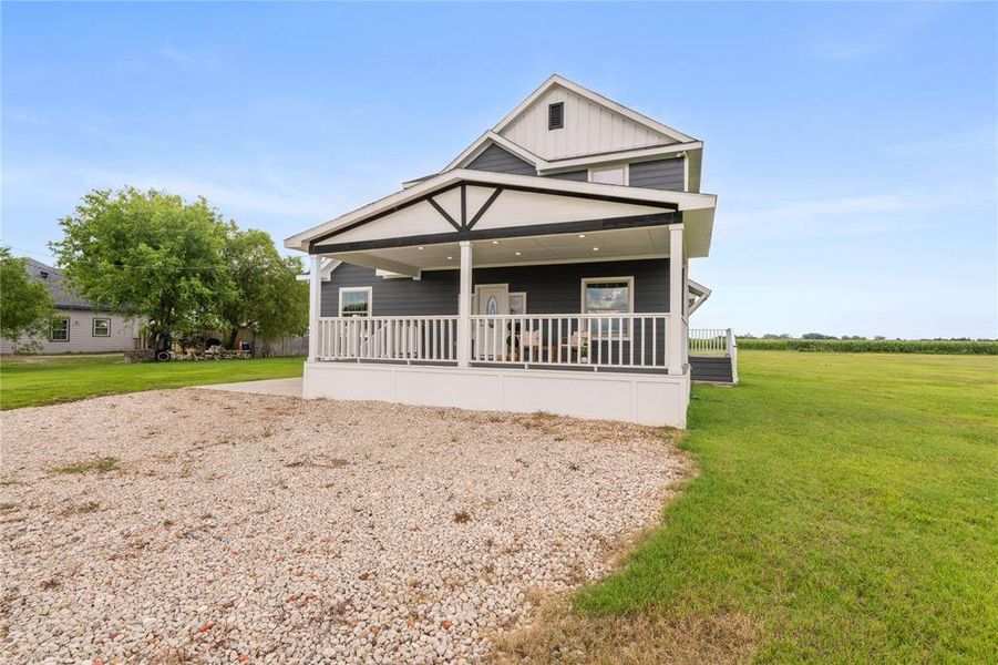 Two-story residence featuring dark siding, white trim, and a covered front porch with white railings