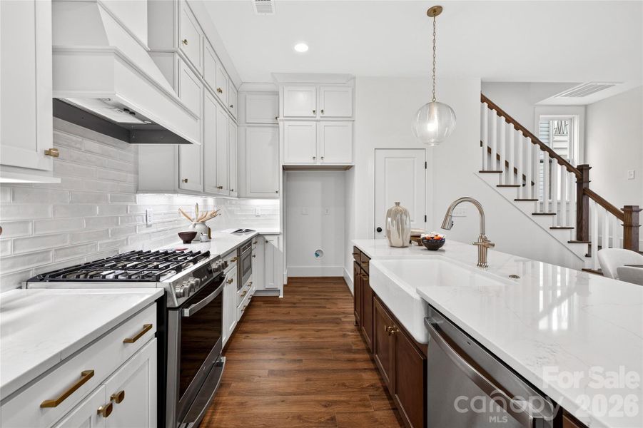 Farmhouse sink and custom wood hood make this kitchen shine.