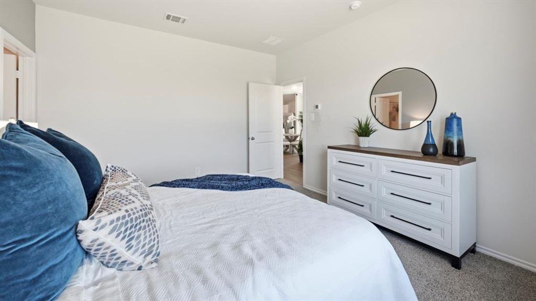 This room features light gray walls, a textured gray carpet, and a white door with a round doorknob