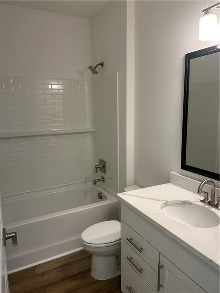 A well-appointed bath features a tiled shower and