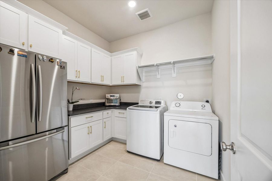 LARGE UTILITY ROOM OFFERS EXTENSIVE CABINET STORAGE, COUNTER SPACE, TILE FLOORING, AND ROOM FOR FULL-SIZE LAUNDRY APPLIANCES. LARGE UTILITY ROOM OFFERS EXTENSIVE CABINET STORAGE, COUNTER SPACE, TILE FLOORING, AND ROOM FOR FULL-SIZE LAUNDRY APPLIANCES.