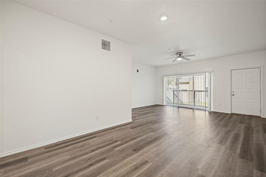 Living room featuring ceiling fan and dark wood-type flooring