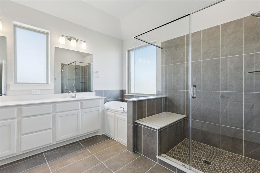 Full bath featuring light tile patterned floors, a stall shower, vanity, and a garden tub