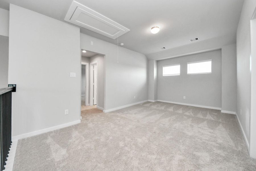 Discover a haven of leisure in this fantastic game room! Whether you're seeking a casual hangout or an adult gaming retreat, this space has it all. Enjoy the luxurious feel of plush carpet underfoot, the expansive ambiance of high ceilings, custom paint that adds a touch of personality, and windows that flood the room with refreshing natural light.