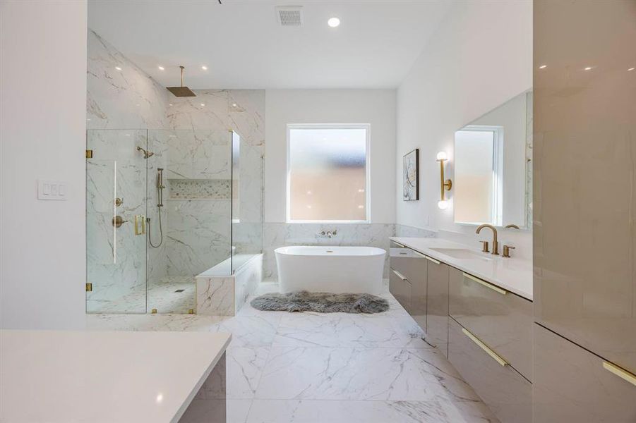 Bathroom with a soaking tub, vanity, a marble finish shower, tile walls, and light marble finish floors Bathroom with a soaking tub, vanity, a marble finish shower, tile walls, and light marble finish floors