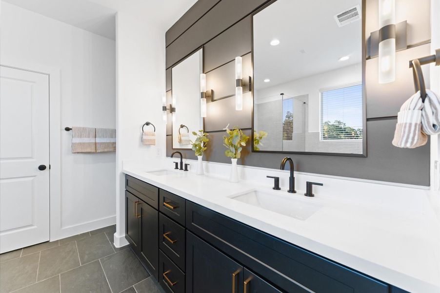 Bright utility room with sleek, modern finishes, featuring hookups for a washer and dryer and ample storage space with dark double doors.