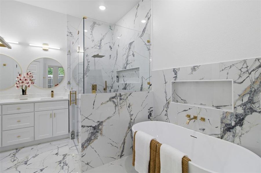 Contemporary bathroom featuring large format marble-look tile flooring and wall accents