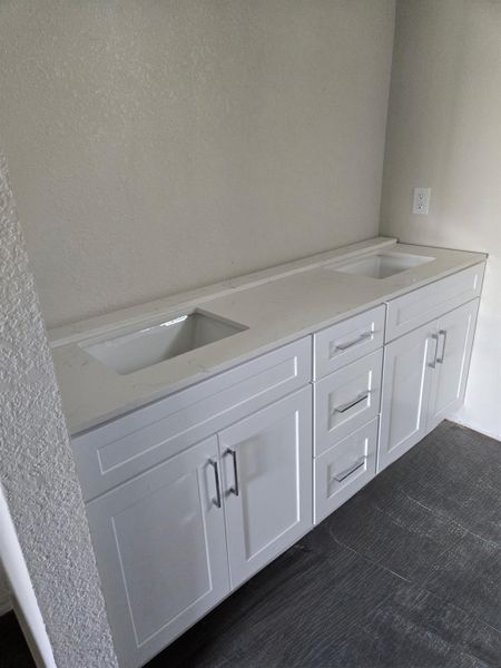 Bathroom featuring double vanity and dark colored carpet
