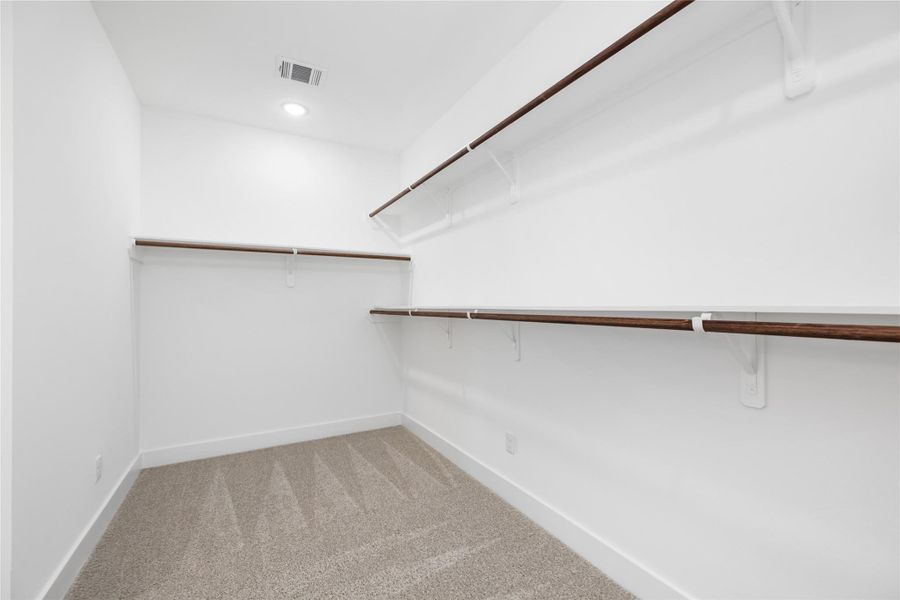 This massive walk-in closet is a true highlight featuring abundant overhead lighting, providing the perfect setting for organization and easy access to your wardrobe.