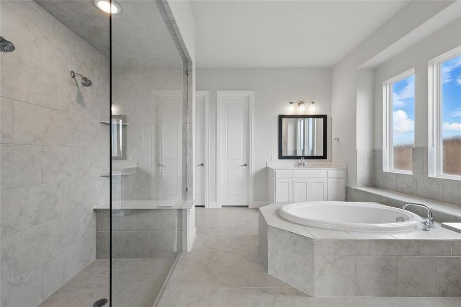 Full bath featuring tiled shower, a garden tub, vanity, and tile patterned flooring