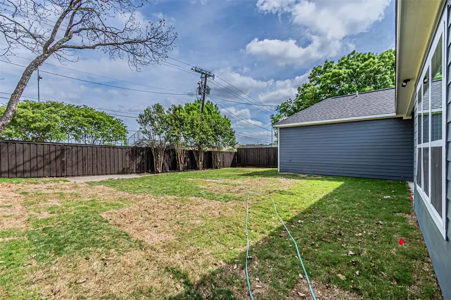 Spacious yard featuring a wood privacy fence and mature perimeter landscaping