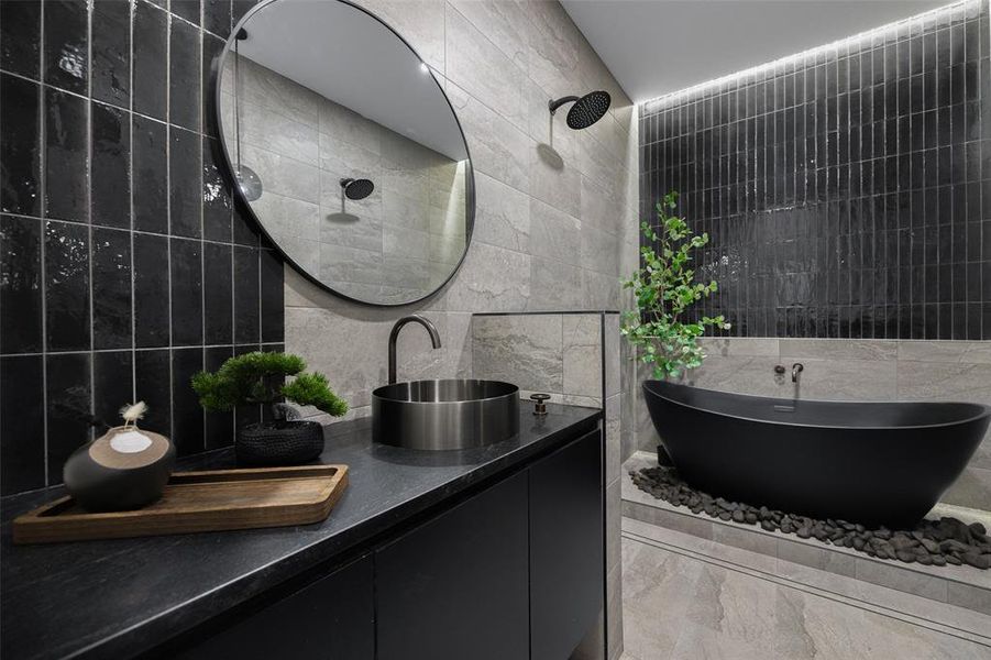 Full bathroom with tile walls, vanity, and a freestanding bath