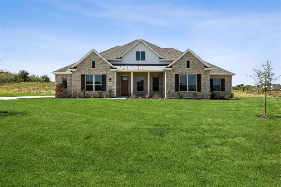 Craftsman-style home featuring a standing seam roof, brick siding, a metal roof, covered porch, and a front yard