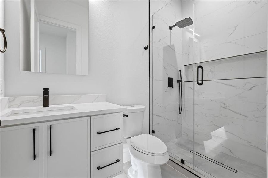 Full bathroom with a marble finish shower and vanity Full bathroom with a marble finish shower and vanity