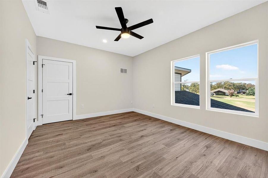 Empty room with light wood-style flooring, ceiling fan, and recessed lighting
