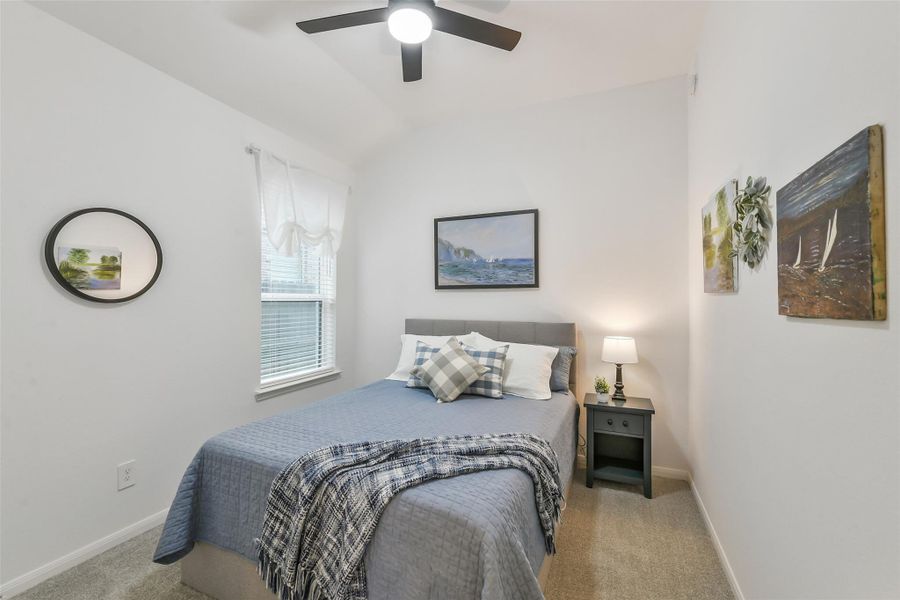 An additional secondary bedroom is spacious and features a ceiling fan and neutral paint.