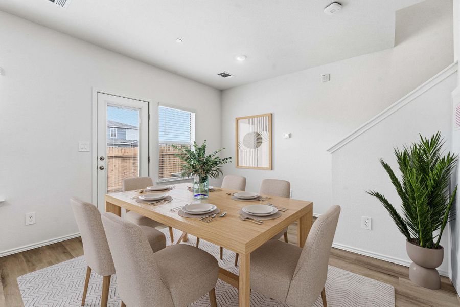 Dining area with wood-finish flooring, white walls, and a glass-paneled exterior door Dining area with wood-finish flooring, white walls, and a glass-paneled exterior door