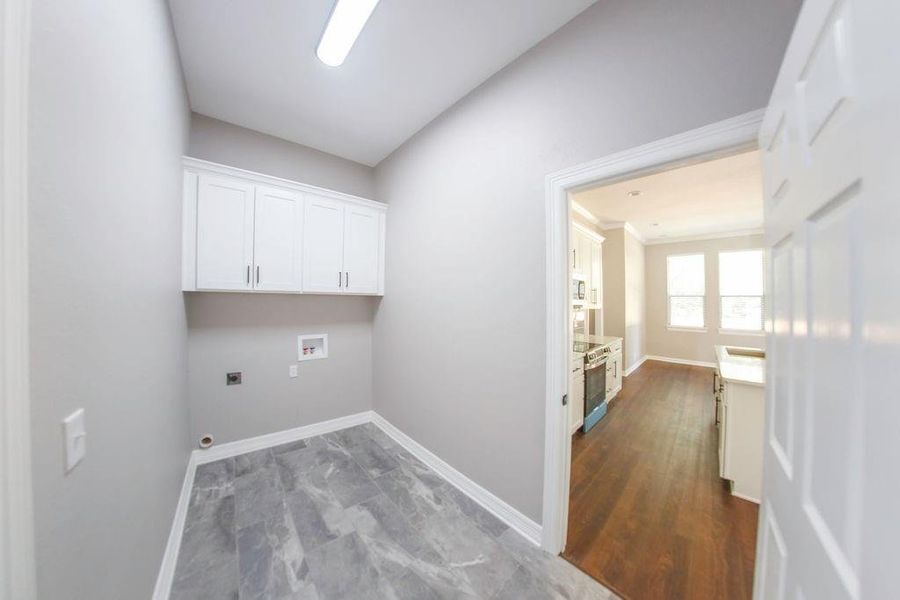 Washroom with hookup for an electric dryer, cabinet space, and washer hookup Washroom with hookup for an electric dryer, cabinet space, and washer hookup