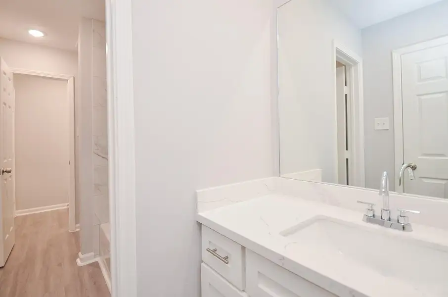 Baño de pasillo con acabados actualizados y ambiente moderno. One for each bedroom.