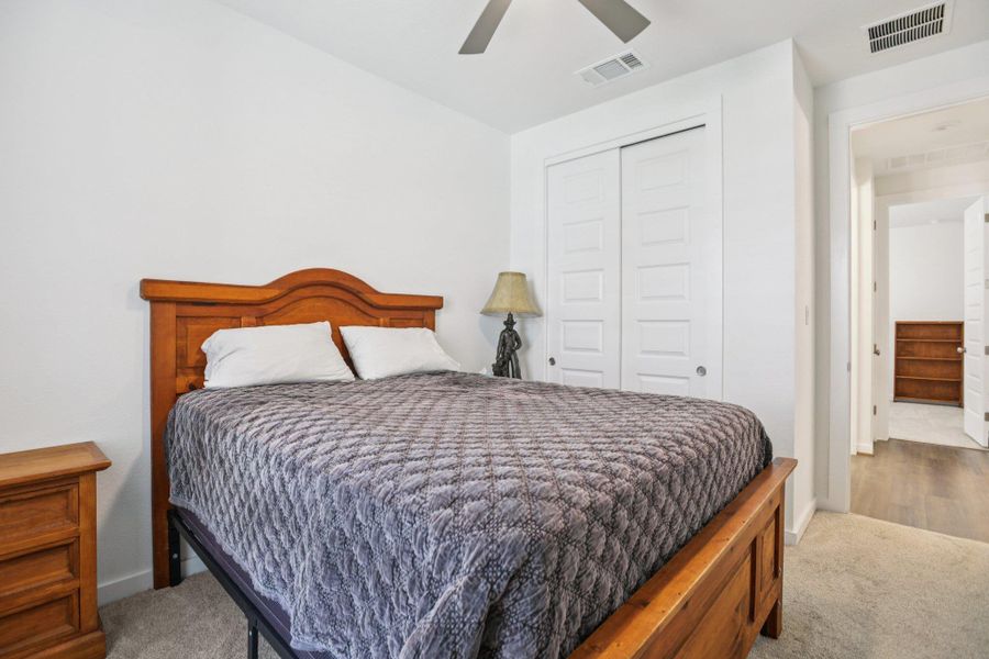 Bedroom featuring a closet, ceiling fan, and carpet Bedroom featuring a closet, ceiling fan, and carpet