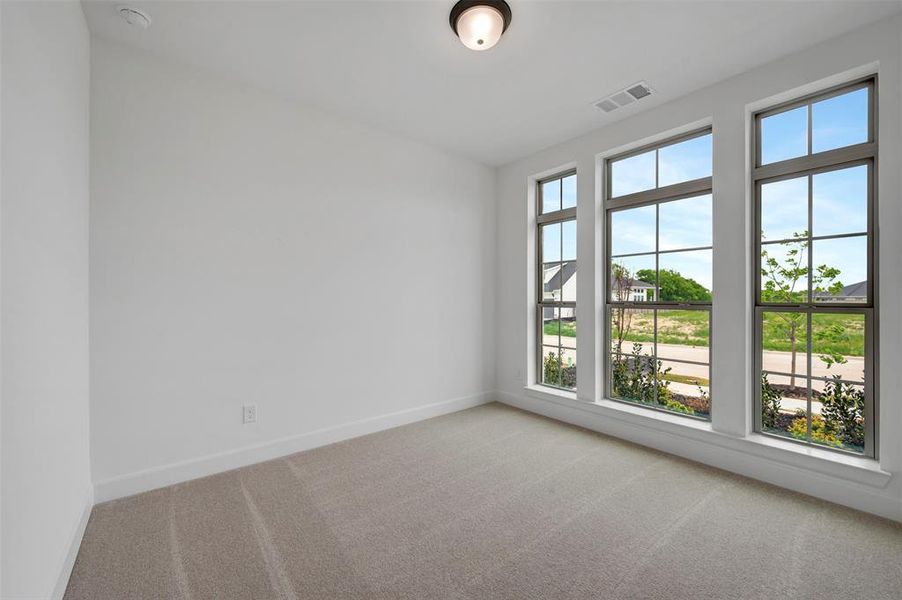 This room features three large windows with grid patterns, providing abundant natural light