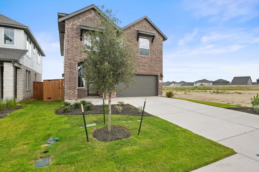 Front exterior of a new home in Terrace Collection at Lariat, Liberty Hill, TX, highlighting curb appeal (Image 23). Front exterior of a new home in Terrace Collection at Lariat, Liberty Hill, TX, highlighting curb appeal (Image 23).