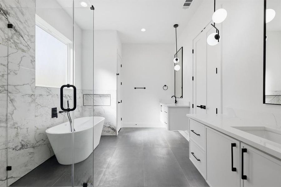 Full bath featuring two vanities, a freestanding bath, tile walls, a marble finish shower, and recessed lighting Full bath featuring two vanities, a freestanding bath, tile walls, a marble finish shower, and recessed lighting