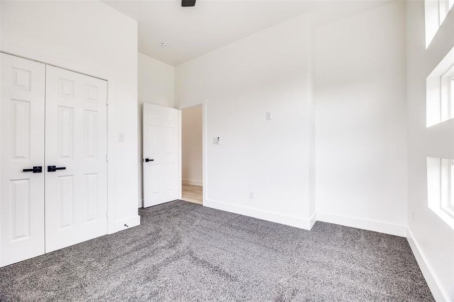 Unfurnished bedroom with carpet floors, a ceiling fan, and a closet Unfurnished bedroom with carpet floors, a ceiling fan, and a closet