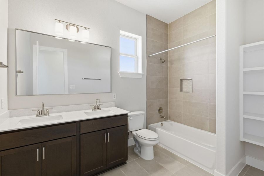 Bathroom with double vanity, tub / shower combination, and light tile patterned flooring