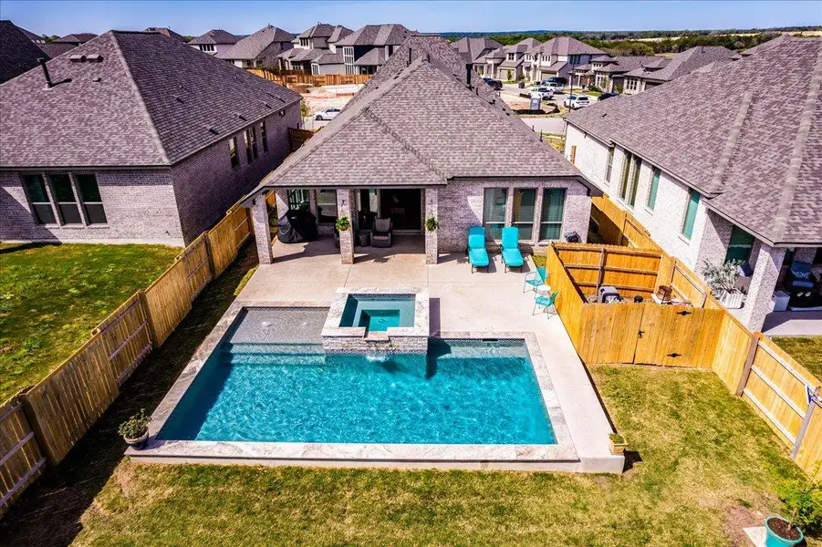 Rear view of property with a patio area, a fenced backyard, and brick siding