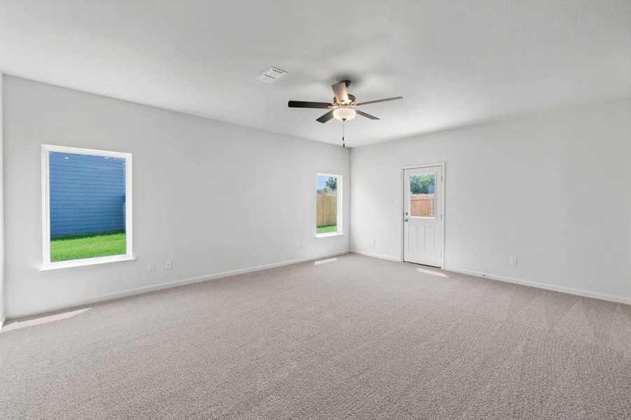 Carpeted living room featuring ceiling fan