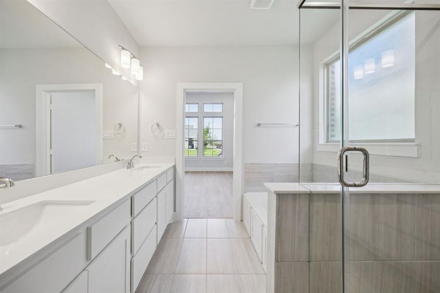 Full bath with a bath, double vanity, a shower stall, and light tile patterned floors