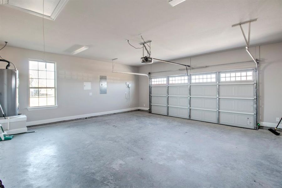 Garage with baseboards and electric panel