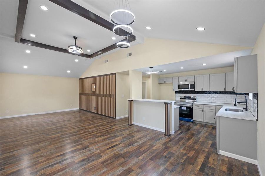 Kitchen featuring ceiling fan, decorative backsplash, beamed ceiling, a center island, and range with electric cooktop