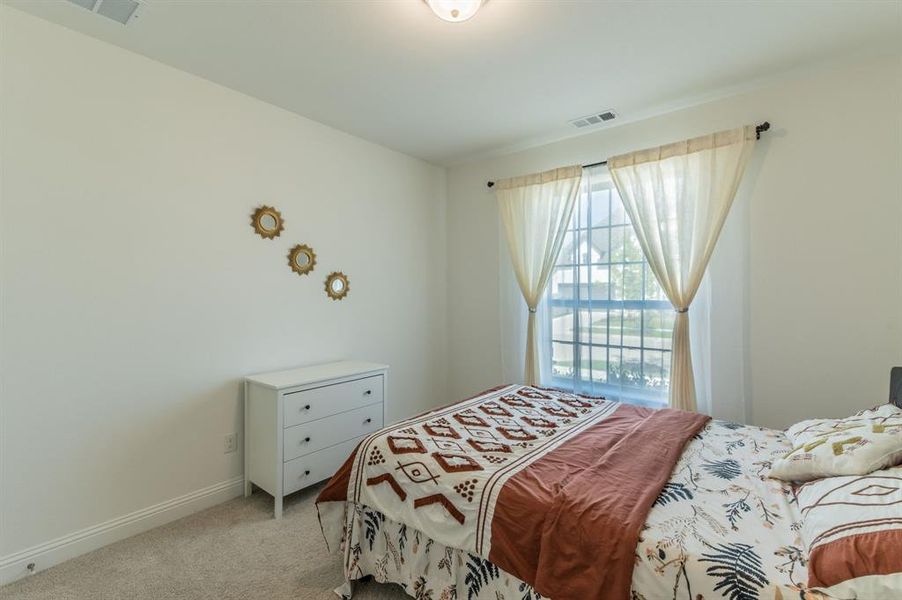 Carpeted interior room featuring white walls and a large window with gridded panes