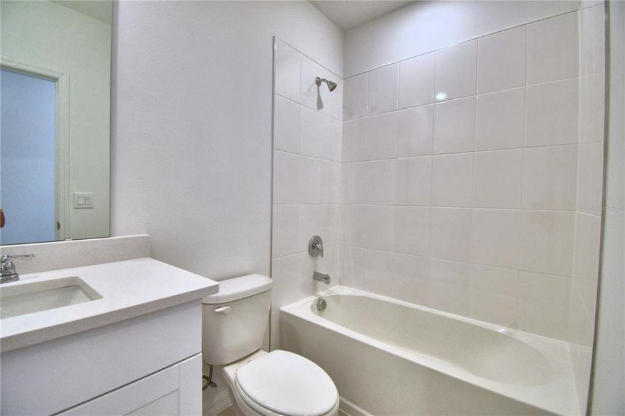 2nd bathroom with tile shower and quartz countertop