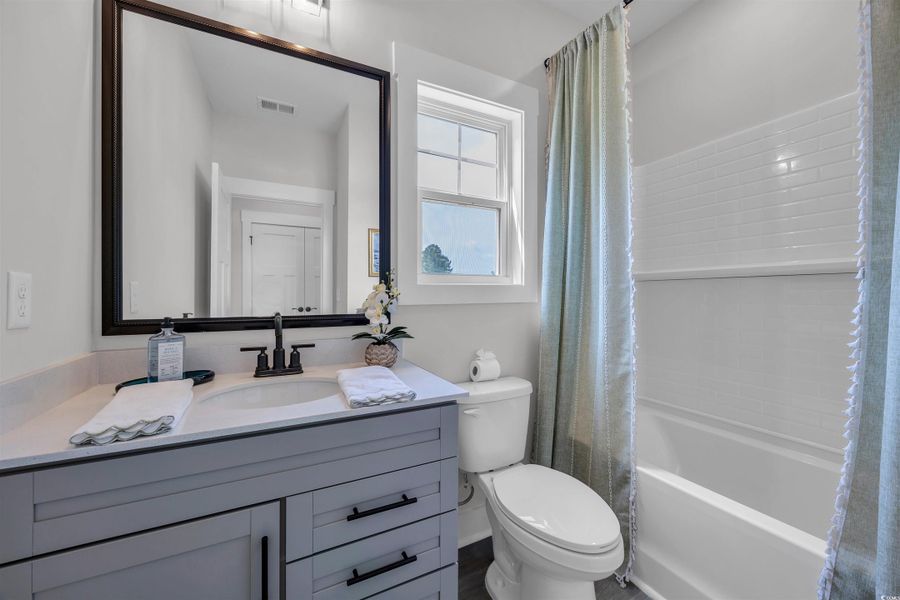 Full bath featuring shower / tub combo with curtain and vanity