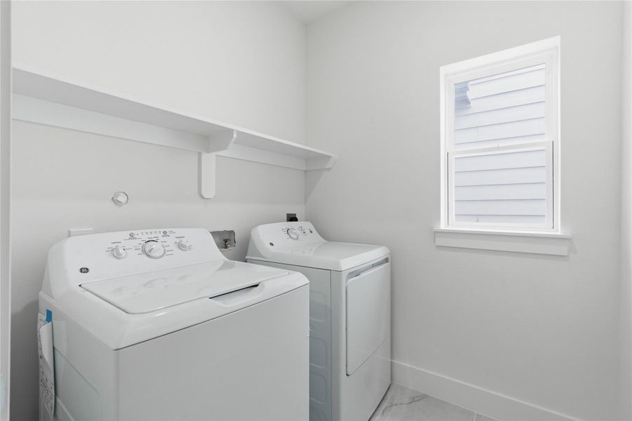 A dedicated laundry room adds everyday convenience with functional space and built-in shelving.