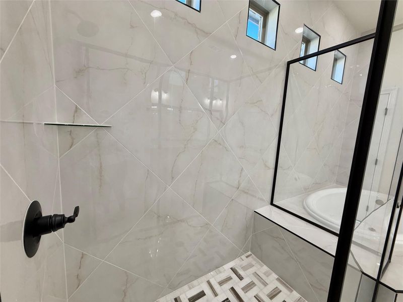 Bathroom with a marble finish shower and a bath