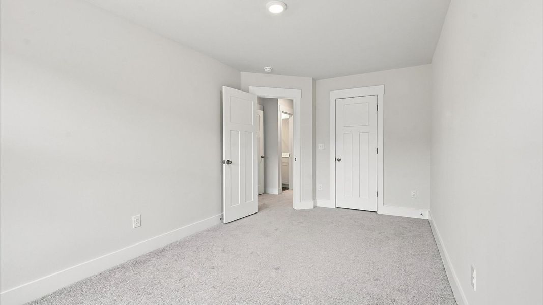 Notable secondary bedroom offering cozy carpeted flooring and a stylish walk-in closet at Ransdell Pointe Notable secondary bedroom offering cozy carpeted flooring and a stylish walk-in closet at Ransdell Pointe