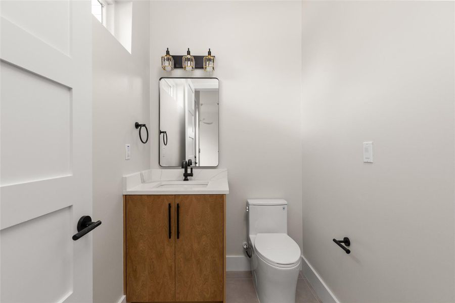 Clean lines and stone counters highlight this modern half bath.